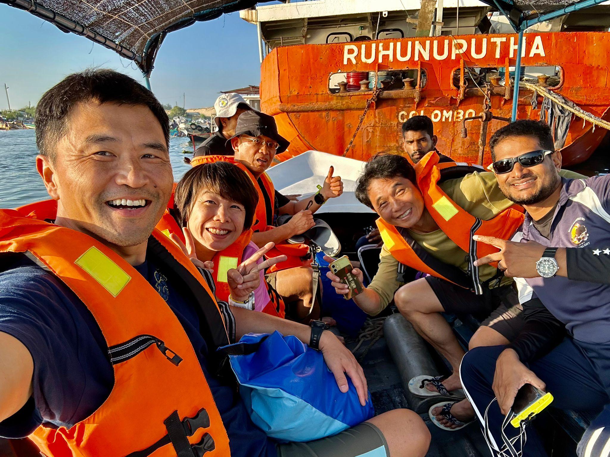 A group of divers celebrating a day of diving on a boat off Colombo